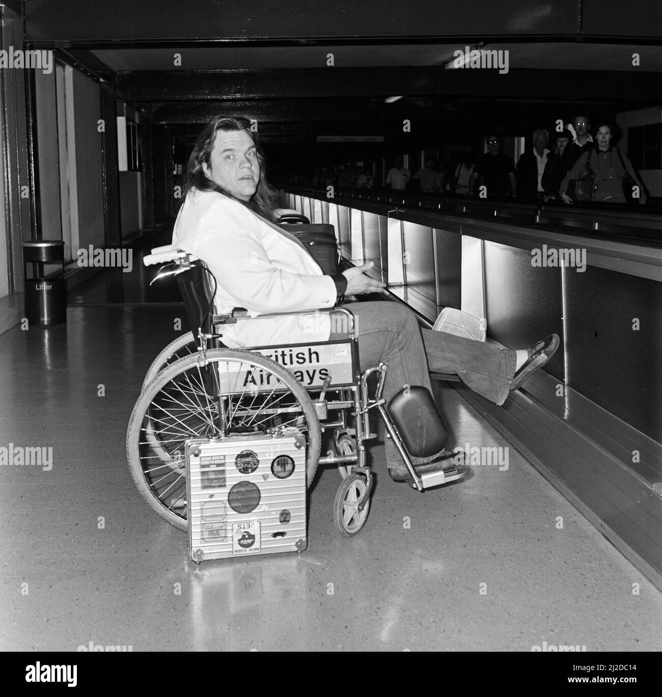 Le chanteur de pop Meat Loaf quitte l'aéroport de Heathrow en fauteuil  roulant. 23rd juin 1985 Photo Stock - Alamy