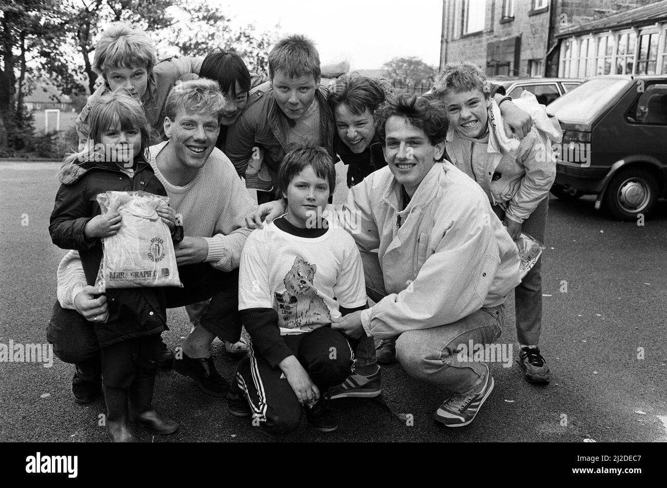 Les footballeurs de ville Simon Webster (à gauche) et Julian Winter font monter le jeune Jason Rushworth en taille pour un T-shirt spécial après qu'il a aidé à effacer la litière de Royds Hall Estate, Paddock. Avec eux sont quelques-uns des 50 autres enfants qui ont pris part à la journée de plaisir de litière pour enfants, organisée par Royds Hall locataires et résidents Association hier. Ils ont également reçu des T-shirts fournis par le nettoyage de Kirklees. 22nd octobre 1986. Banque D'Images