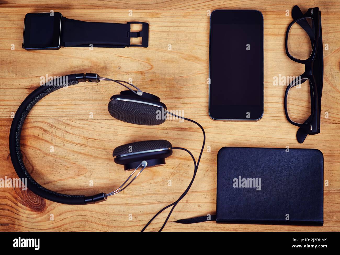 Des outils pour rendre un boxer heureux. Prise de vue d'un casque, d'un ordinateur portable, de lunettes, d'un smartphone et d'une montre intelligente sur une table. Banque D'Images