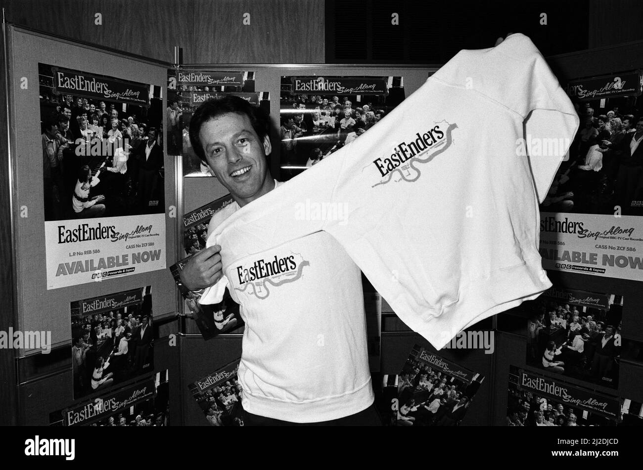 « Dirty Den », alias Leslie Grantham, propriétaire de la Reine Victoria, avait un emploi à temps partiel pour vendre des t-shirts et des tasses de café EastEnders. 29th novembre 1985. Banque D'Images