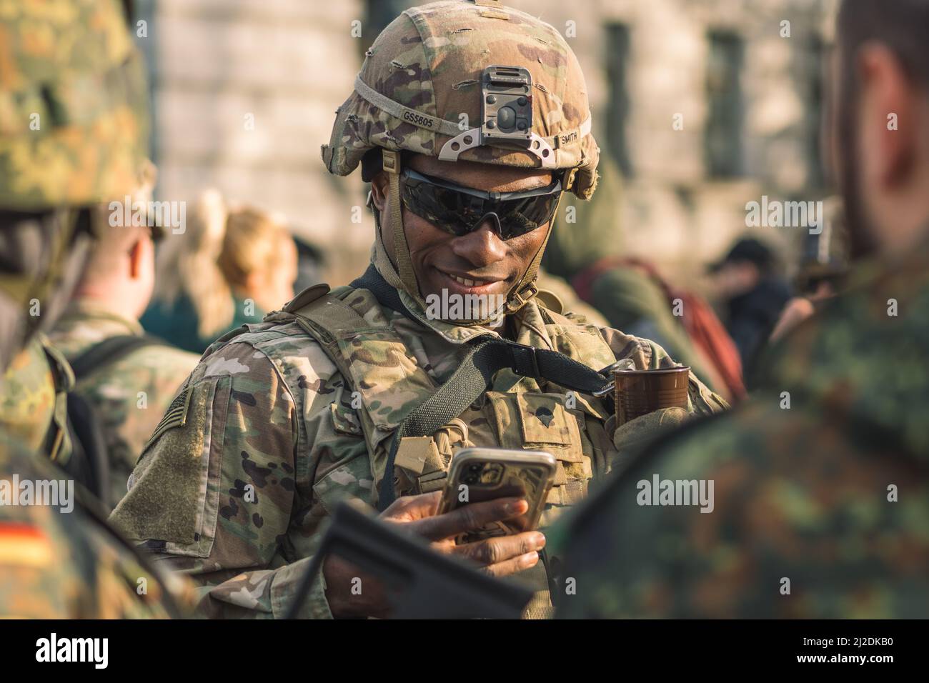 Soldat souriant du corps des Marines des États-Unis avec des lunettes de soleil, un fusil de chasse et un véhicule blindé humvee en arrière-plan pendant la guerre, les troupes des États-Unis ou de l'armée américaine Banque D'Images