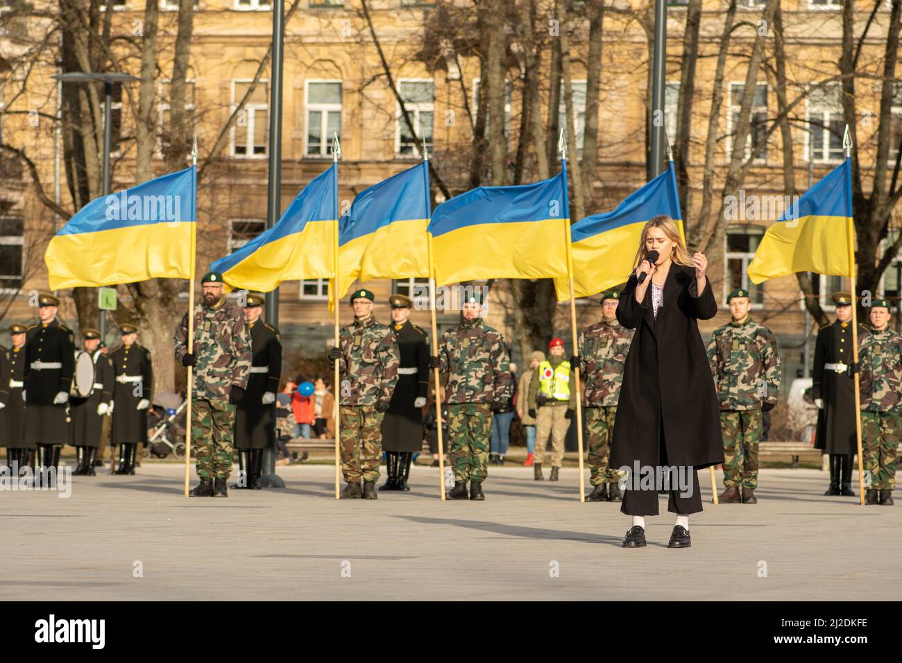 Drapeaux de l'Ukraine lors d'une cérémonie à Vilnius avec des soldats et un beau chanteur ukrainien chantant l'hymne national Banque D'Images