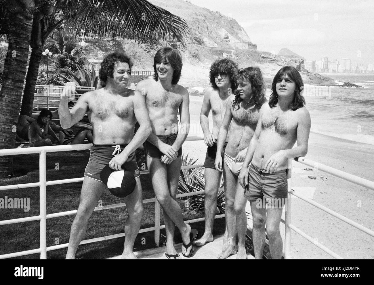 Le groupe de rock australien AC/DC prend le temps de se détendre à la plage d'Ipanema à Rio de Janeiro, au Brésil, lors de sa visite en Amérique du Sud. Ils sont dans la ville pour se produire au festival Rock in Rio au Rockedome, en terminant leur tournée mondiale « Flick of the Switch ». De gauche à droite : chanteur Brian Johnson, Cliff Williams, Simon Wright, Angus Young, Malcolm Young. Janvier 1985. Banque D'Images