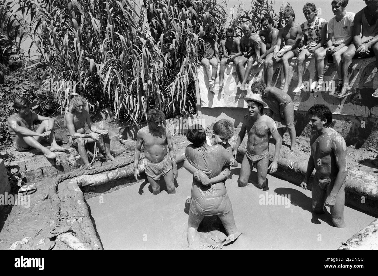 Des jeunes en vacances à Corfou en vacances au Club 18-30. Deux jeunes luttent dans la boue. Août 1986. Banque D'Images