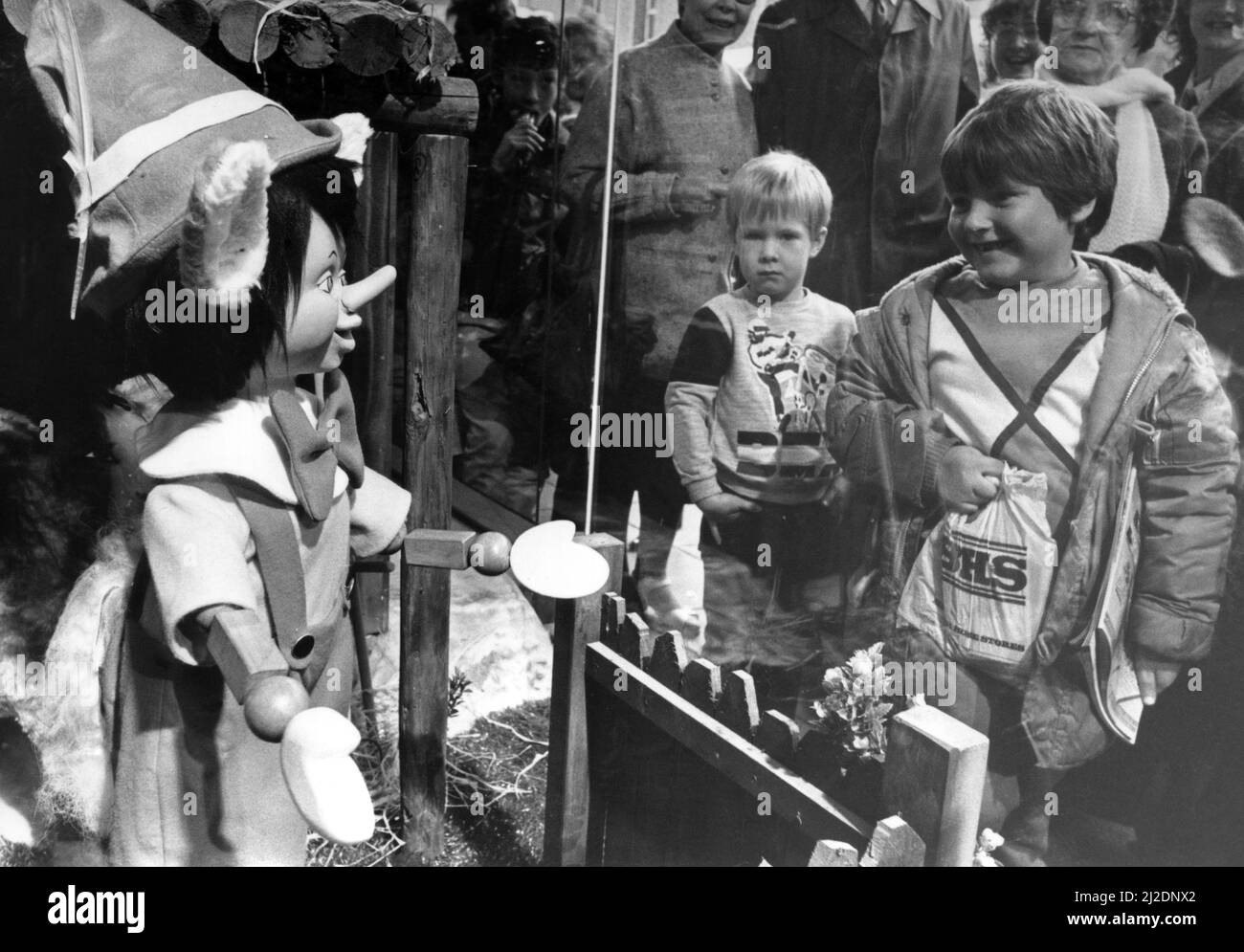 Les enfants rencontrent Pinocchio par la fenêtre du magasin Fenwick à Newcastle. 9th novembre 1985. Banque D'Images