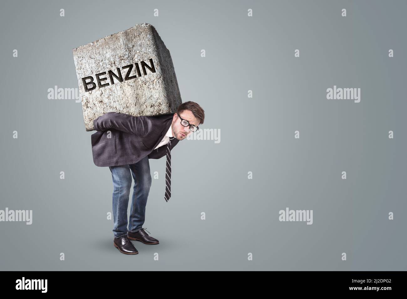 Personne accablée par une pierre lourde avec le mot BENZIN dessus Banque D'Images