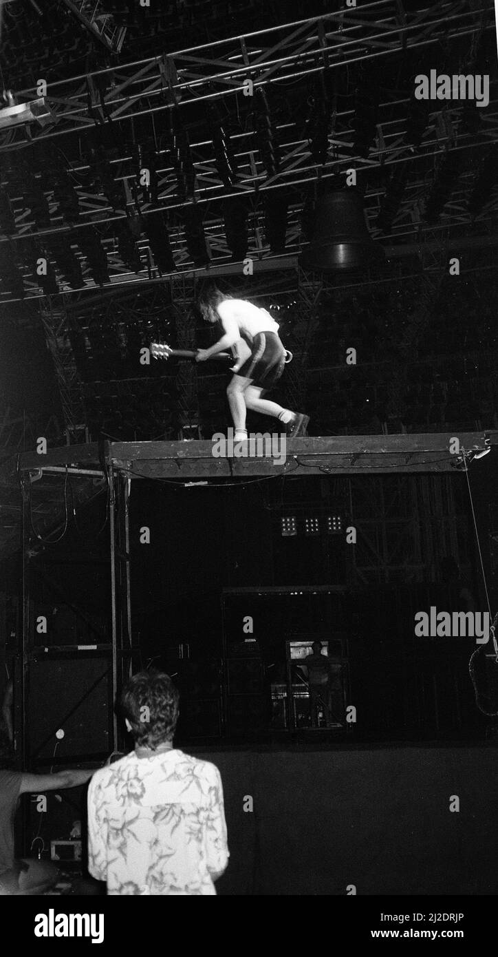 Groupe de rock australien AC/DC se présentant en concert au Rockedome à Rio de Janeiro, au Brésil, lors du festival Rock in Rio, pour conclure leur tournée mondiale « Flick of the Switch ». Le guitariste Angus Young se tient sur scène au-dessus du système de haut-parleurs géant. Janvier 1985. Banque D'Images