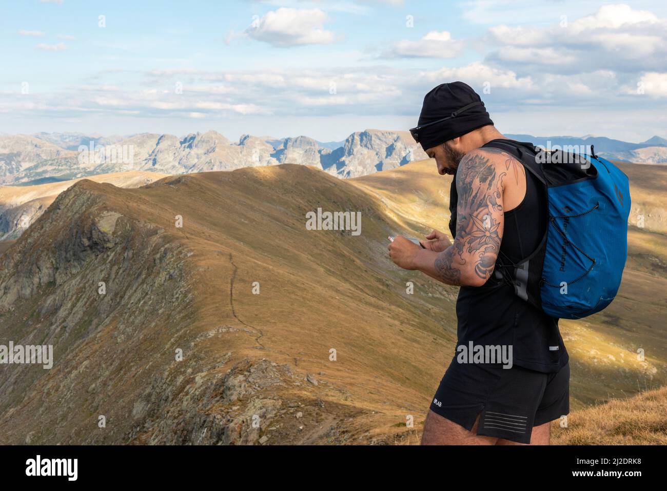 Guide de randonnée vérifiant l'itinéraire sur smartphone à Otovitsa Peak à 2697m sur le sentier longue distance européen E4, Rila Mountain, Bulgarie Banque D'Images