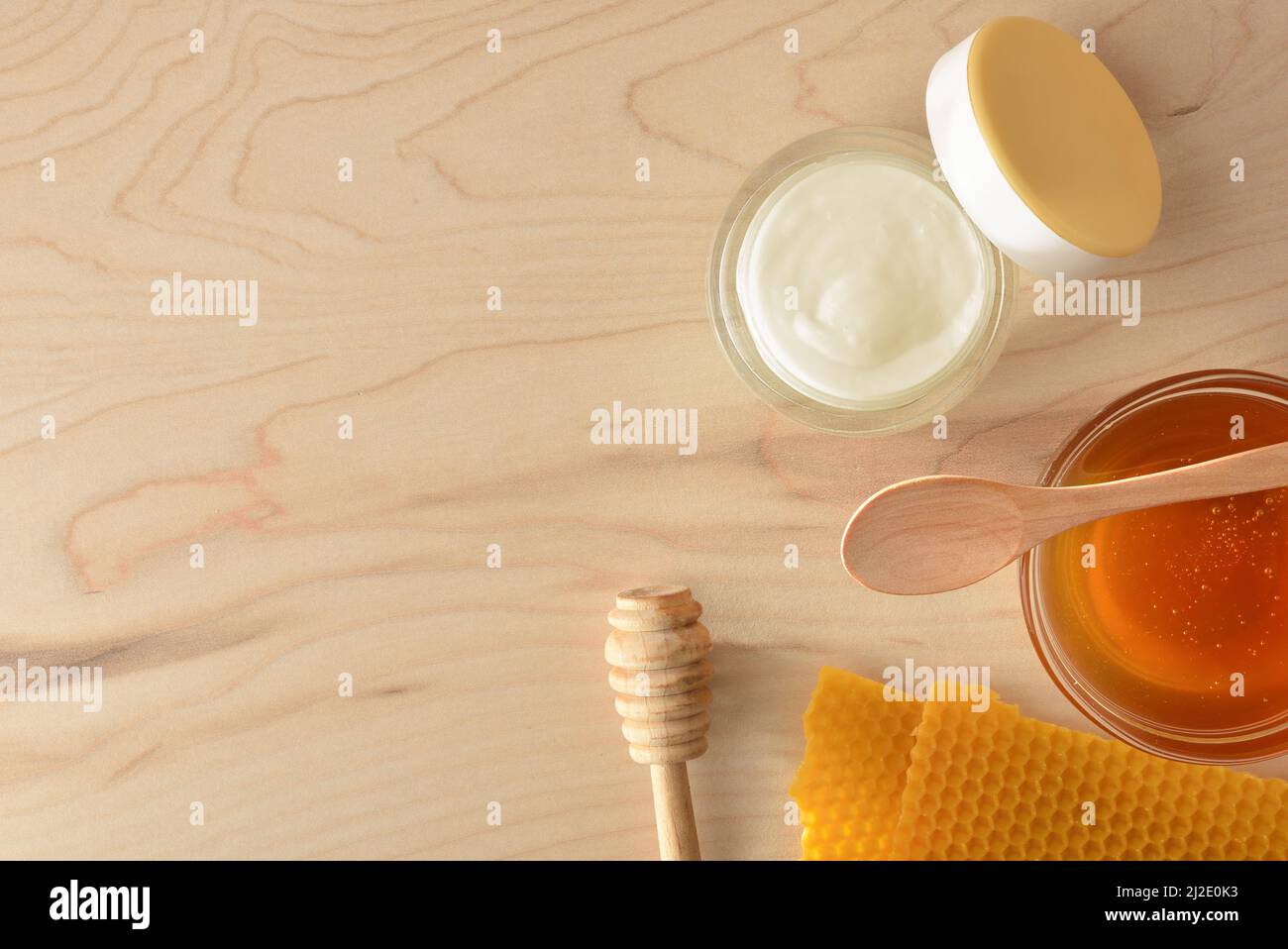 Crème hydratante pour les soins de la peau avec extraits de miel et rayons de miel sur une table en bois. Composition horizontale. Vue de dessus. Banque D'Images
