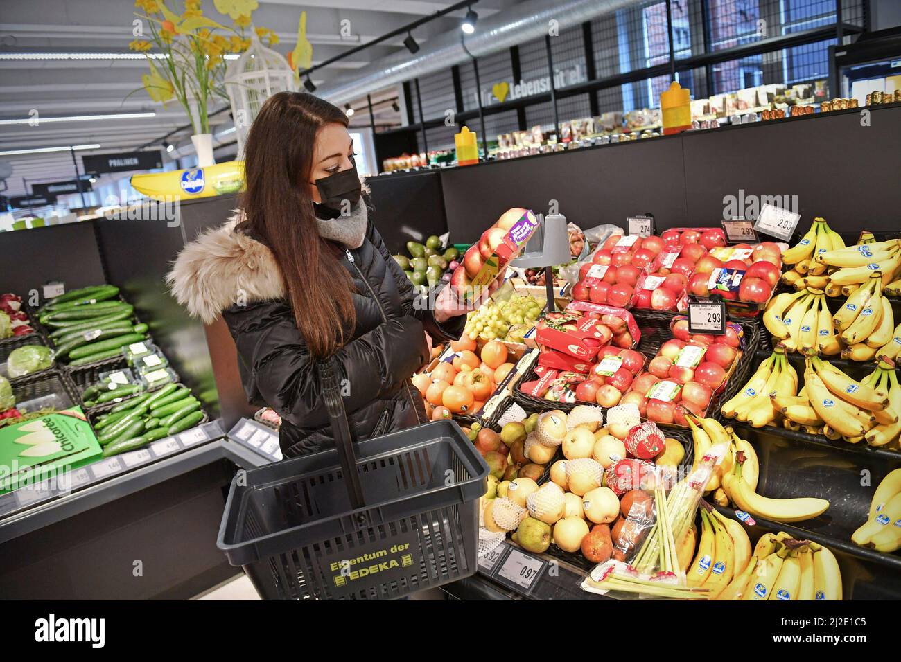 ARCHIVE PHOTO: À partir du 2nd avril 2022, les masques ne seront plus obligatoires lorsque les achats et les clients devront se préparer à d'autres augmentations de prix. Image thématique de la pandémie du coronavirus en automne/hiver, jeune femme avec un panier d'achats dans un supermarché le 17th novembre 2020 à Munich-elle est debout devant le comptoir des fruits et porte un masque facial. MODÈLE DISPONIBLE ! Â Banque D'Images