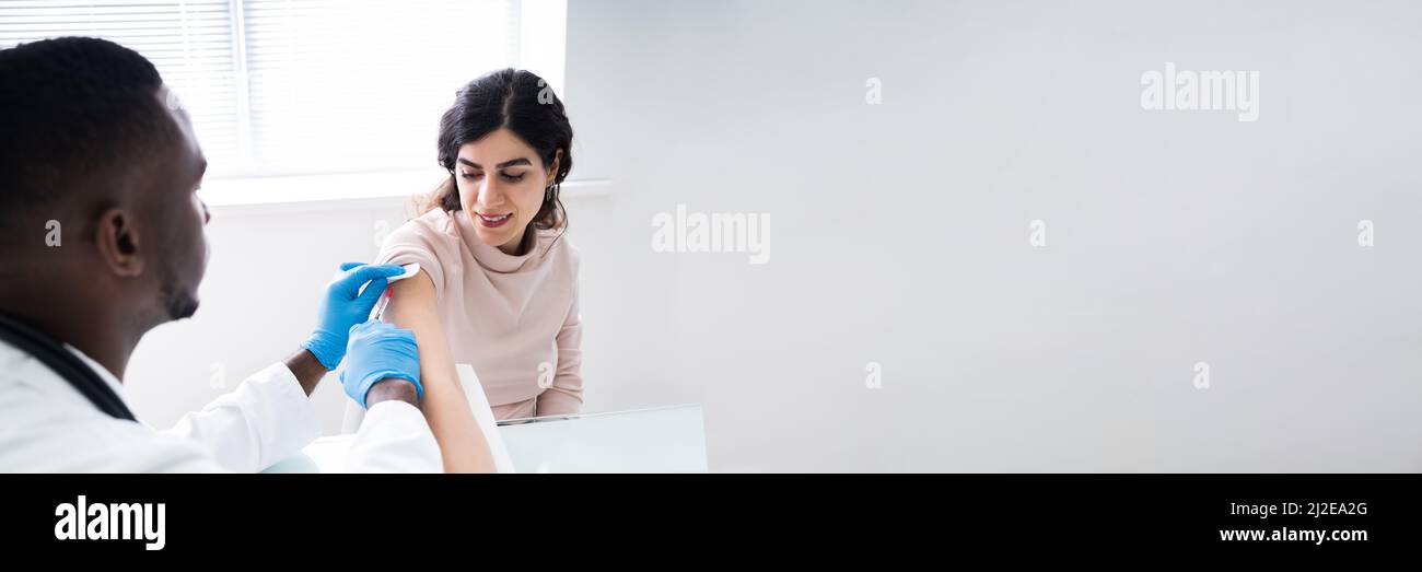 Injection manuelle par le médecin d'un patient avec un vaccin contre le coronavirus Banque D'Images