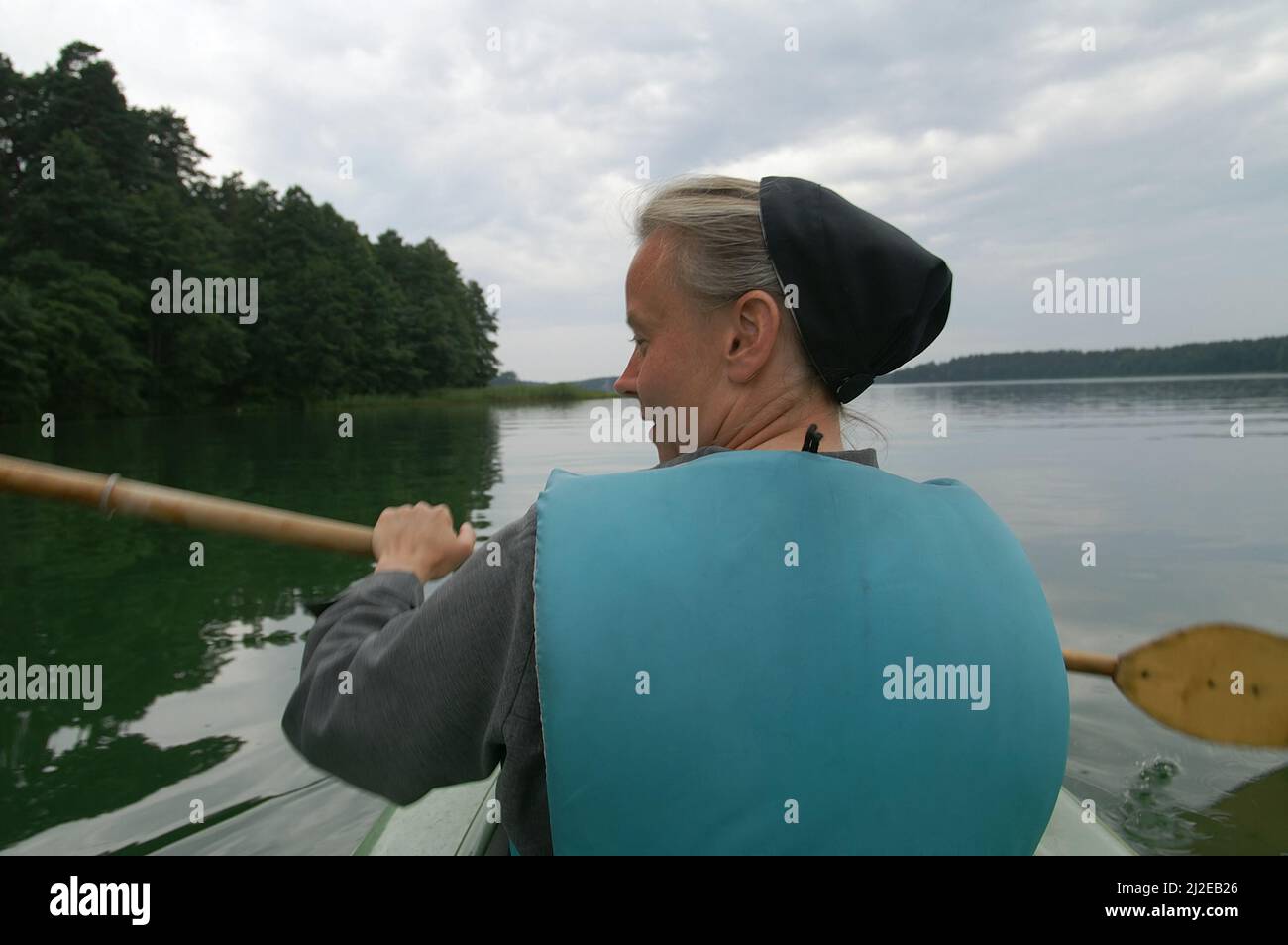 Augustów, Pologne, Polen, Polska, Une nonne de canoë dans une gilet de vie. Eine Nonne, die in einer Schwimmweste Kanu fährt. Kanufahren 穿著救生衣劃獨木舟的修女。 Banque D'Images