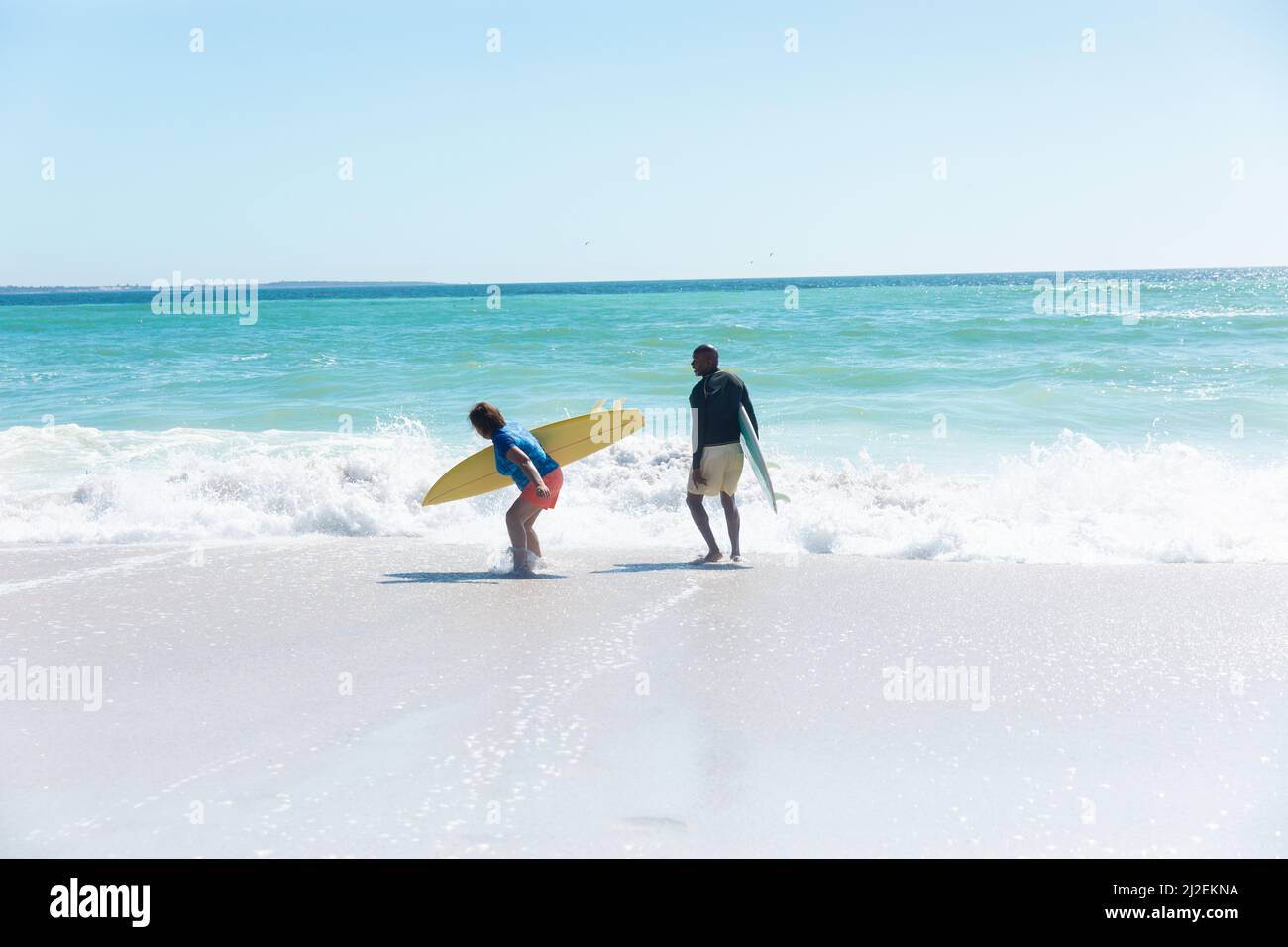 Couple senior afro-américain à la retraite bénéficiant d'une journée ensoleillée à la plage contre le ciel bleu avec espace de copie Banque D'Images