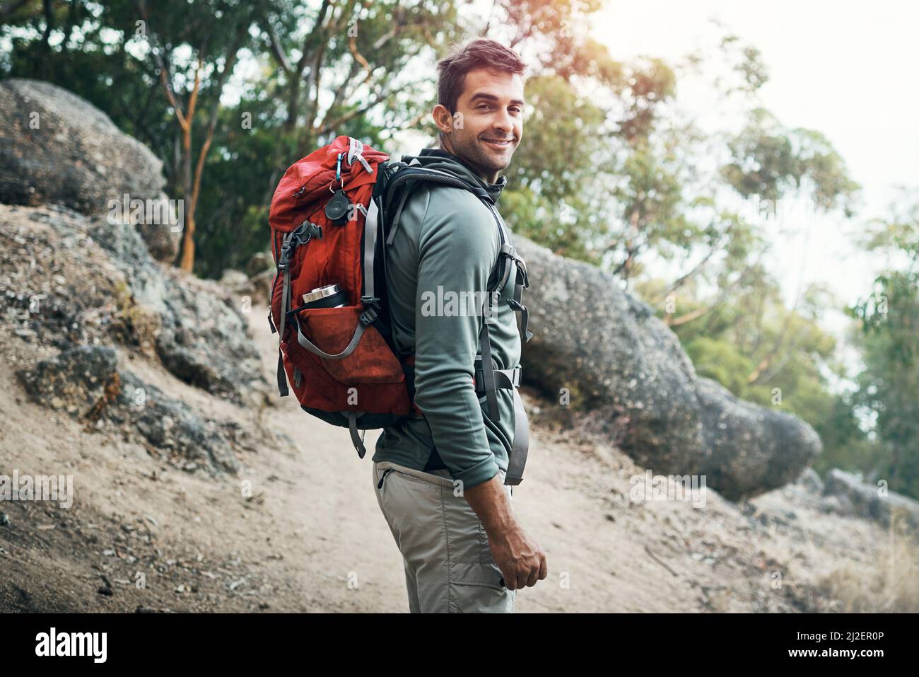 Partez à l'aventure. Portrait d'un jeune homme joyeux portant un sac à dos et prêt à monter en montagne. Banque D'Images