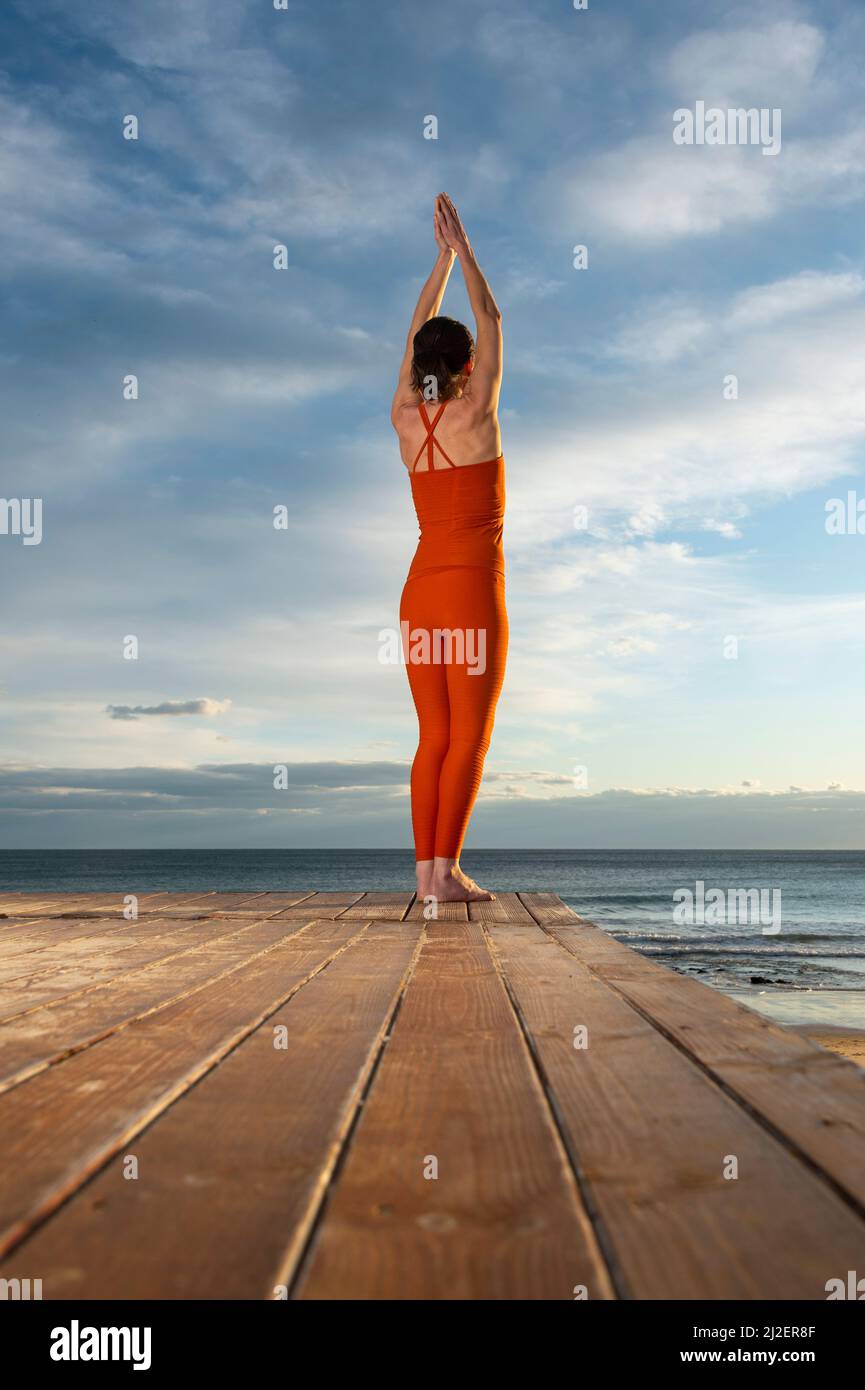 femme pratiquant le yoga à l'extérieur près de la mer. Harmonie et méditation concept. Mode de vie sain Banque D'Images