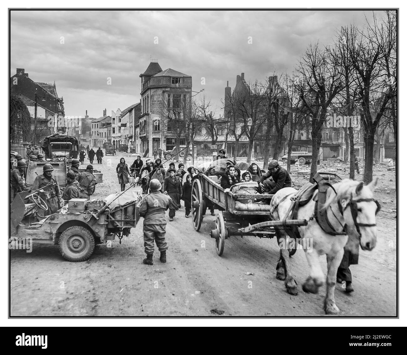 La bataille de l'Bulge WW2 réfugiés évacuant la ville belge de Bastogne les troupes américaines de la Seconde Guerre mondiale maintiennent la ville contre les puissants coups de fer de l'ennemi nazi de l'Allemagne. En hommage aux exploits héroïques des forces américaines, Bastogne a érigé des monuments commémoratifs en leur honneur Date 1944 Seconde Guerre mondiale Banque D'Images