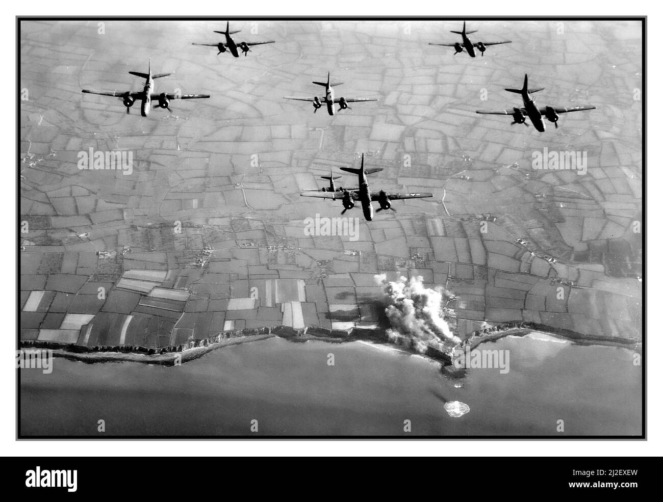 D-Day WW2 pré-invasion aérienne juin 1944 bombardement ponctuel de la Pointe du hoc Normandie Nord de la France, image des bombardiers de la neuvième Force aérienne B26 de l'USAF bombardant les fortifications nazies avant l'invasion du D-Day. Pointe du hoc a été l'emplacement d'une série de bunkers allemands et de postes de mitrailleuses. Avant l'invasion de la Normandie, l'armée allemande a fortifié la région avec des casémates en béton et des puits d'armes à feu. Le jour J, le groupe d'assaut des Rangers de l'armée des États-Unis a attaqué et capturé la Pointe du hoc après avoir élancé les falaises. Banque D'Images