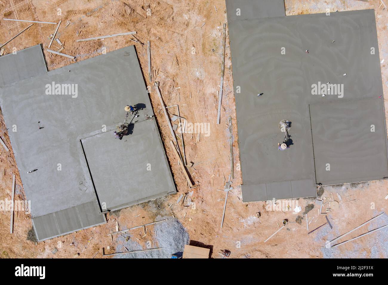 Vue aérienne de la main-d'œuvre le polissage de travail frottant avec béton ciment fond de fondation à la maison sous le chantier de construction Banque D'Images