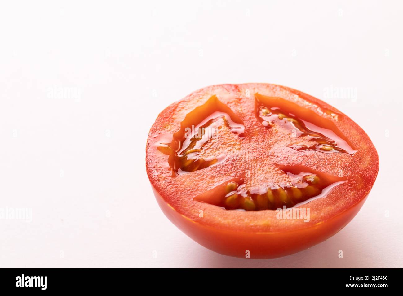 Gros plan de la tomate rouge fraîche à moitié par espace de copie sur fond blanc Banque D'Images