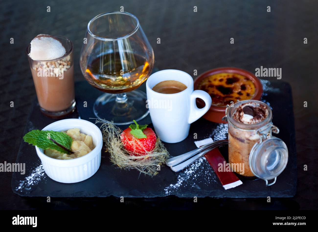 Grand dessert et verre d'Armagnac sur un plateau en ardoise Banque D'Images