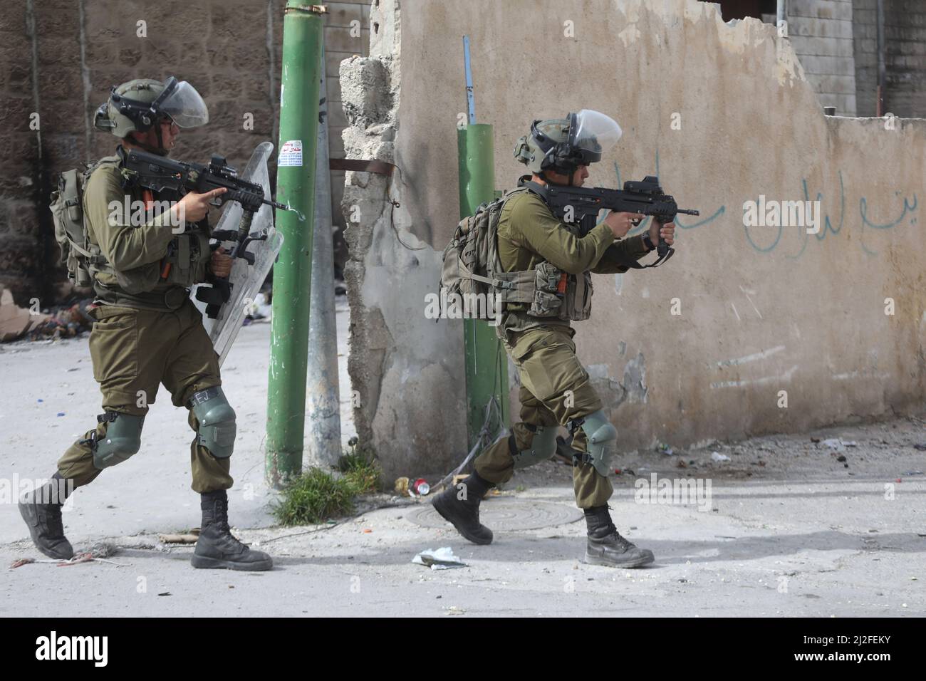 Hébron. 1st avril 2022. Des soldats israéliens détiennent leurs armes lors d'affrontements avec des manifestants palestiniens à la suite d'une manifestation contre l'expansion des colonies juives dans la ville d'Hébron en Cisjordanie, le 1 avril 2022. Crédit: Mamoun Wazwaz/Xinhua/Alamy Live News Banque D'Images