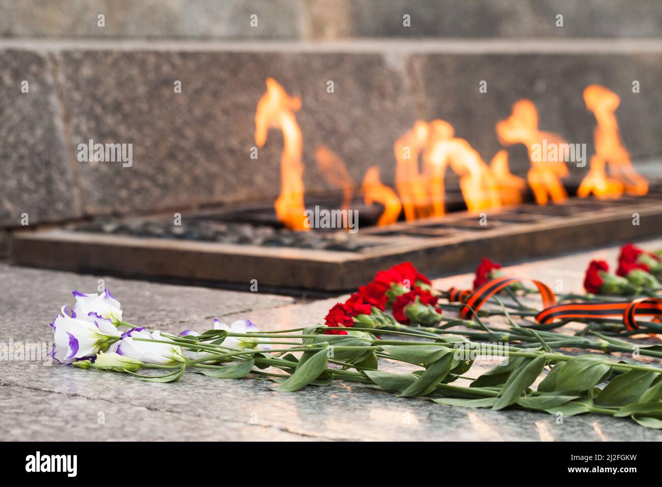 Mémorial de la Seconde Guerre mondiale des soldats soviétiques en Russie. Les fleurs se trouvent à une flamme éternelle d'un lit d'honneur, photo de près avec des fleurs sélectives Banque D'Images