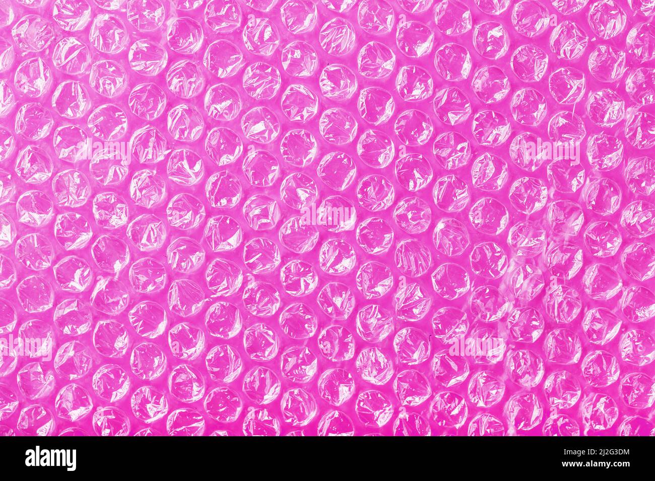 La texture du film à bulles d'air d'emballage sur fond rose en plein écran Banque D'Images