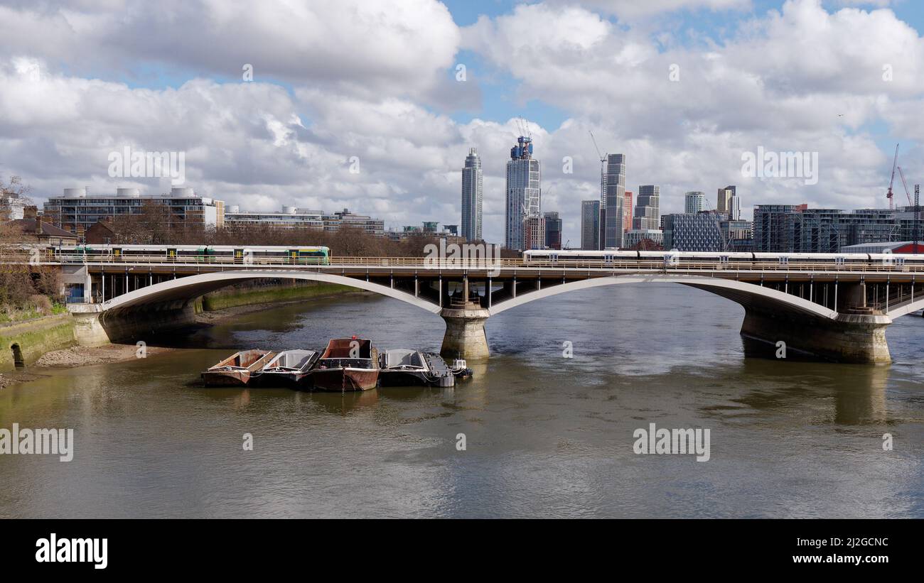 Londres, Grand Londres, Angleterre, mars 12 2022 : des bateaux cargo amarrés sous un pont au-dessus de la Tamise à Battersea. Banque D'Images