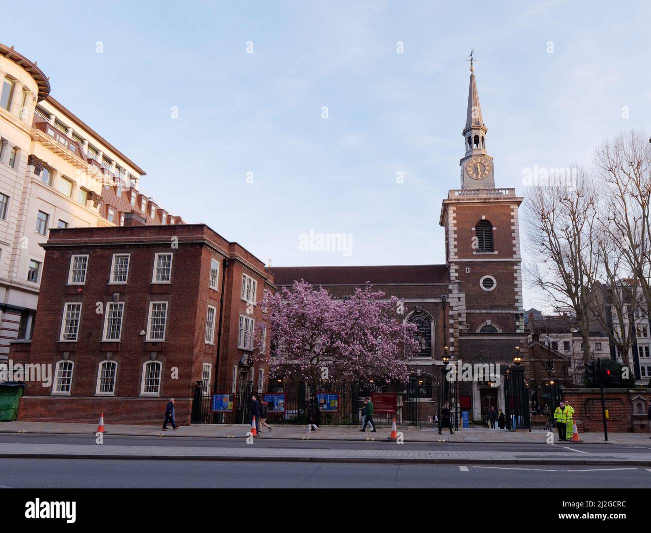 Londres, Grand Londres, Angleterre, mars 12 2022 : église anglicane St James sur Piccadilly Street avec Cherry Blossom devant les piétons. Banque D'Images