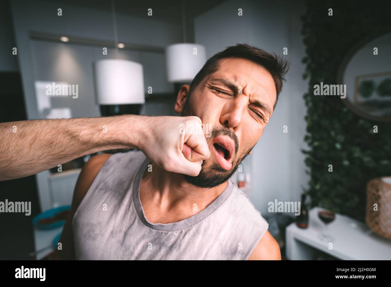 L'homme prend le coup dur dans le visage. Deux hommes se battent. Homme frappant l'homme dans le visage avec le poing. Conflit et violence Banque D'Images