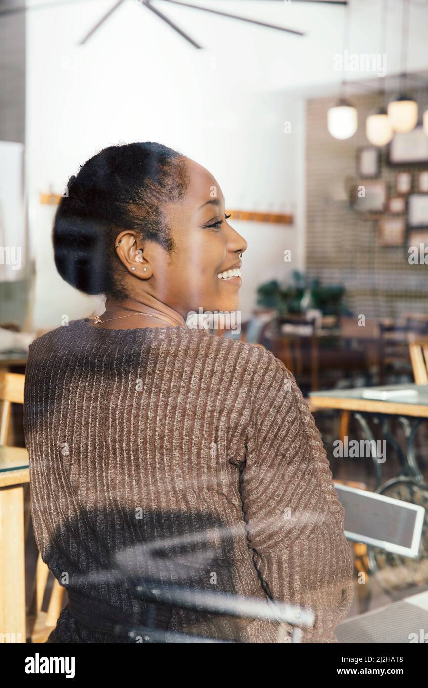 Femme souriante avec une tablette numérique dans un café Banque D'Images