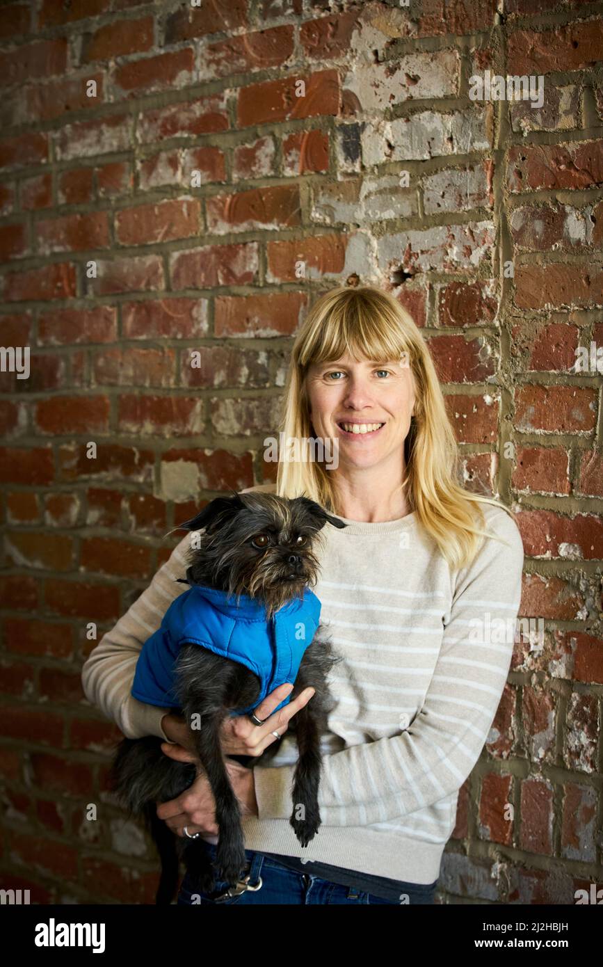 Portrait d'une femme mûre souriante tenant son chien Banque D'Images