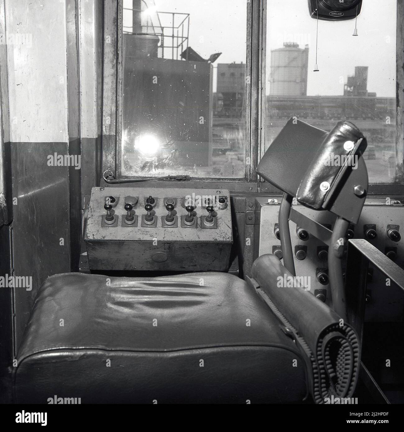 1950s, vue historique et intérieure d'une cabine de grue montrant le siège et les commandes. La grue déplacerait un gros aimant pour mettre de la ferraille d'acier et d'autres métaux jetés dans des wagons de marchandises, usine d'acier d'Abbey Works, Port Talbot, pays de Galles, Royaume-Uni. Banque D'Images