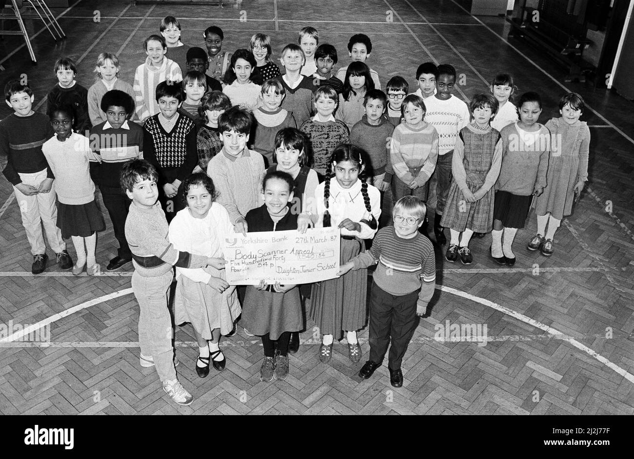 Prouvant qu'ils ont une bonne tête pour les chiffres sont ces enfants de la Deighton Junior School, qui ont recueilli £540,54 pour le £1/2m Examiner Bodyscanner Appeal. Plus de 160 enfants de l'école ont été parrainés pour apprendre leurs tables de temps. Un groupe d'entre eux est photographié avant de remettre un chèque géant à l'appel. 27th mars 1987. Banque D'Images
