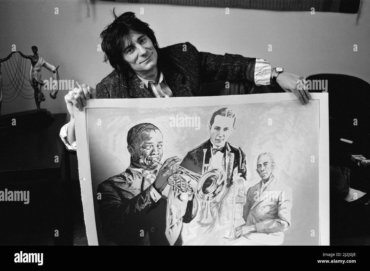 Ronnie Wood, photographié en 1987 avec ses dessins. Ces dessins seraient finalement peints en couleur. Dans cette photo, Ronnie tient son dessin Louis Armstrong (à gauche) Leon Bismark 'Bix' Beiderbecke (au centre) et Bunk Johnson (à droite). Tous les musiciens du 1930s. Photo prise le 20th octobre 1987 Banque D'Images