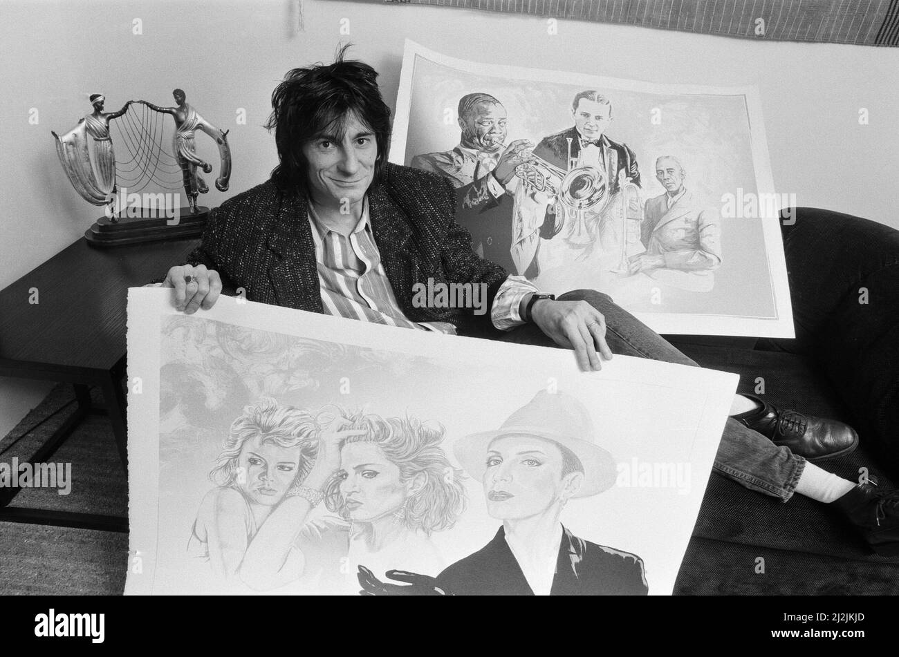 Ronnie Wood, photographié en 1987 avec ses dessins. Ces dessins seraient finalement peints en couleur. Sur cette photo, Ronnie présente Kim Wilde (à gauche) Madonna (au centre) et Annie Lennox (à droite). Musiciens du 1980s. En arrière-plan, il s'agit de Louis Armstrong (à gauche) Leon Bismark 'Bix' Beiderbecke (au centre) et de Bunk Johnson (à droite). Tous les musiciens du 1930s. Photo prise le 20th octobre 1987 Banque D'Images
