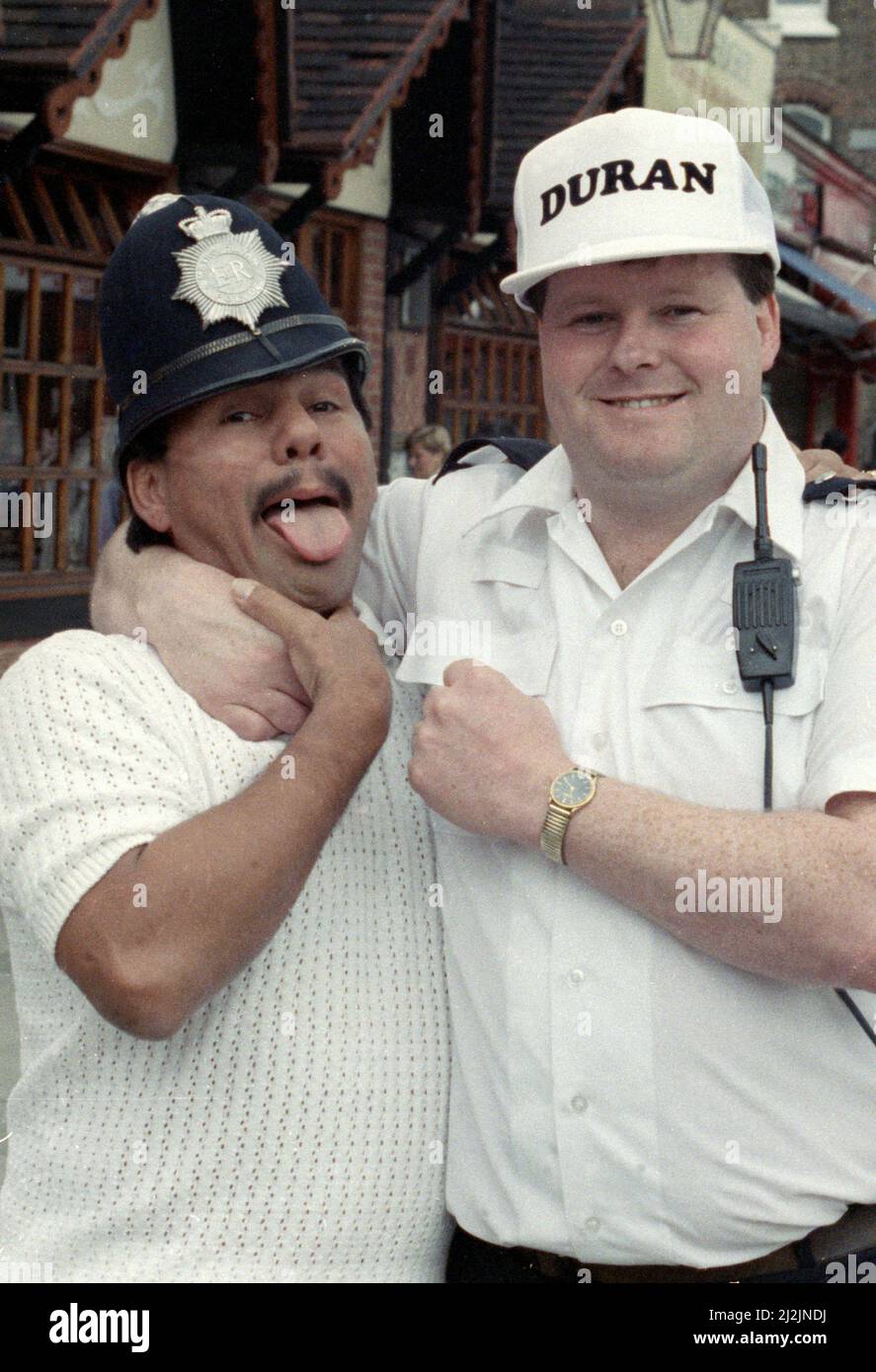 Poids moyen Boxer Roberto Duran vu ici dans les bras de la loi comme il l'jambons avec West Ham battre la Communauté PC Agent John Boden. Duran est à Londres pour une exposition lutte avec Errol Christie. 11 Juillet 1988 Banque D'Images