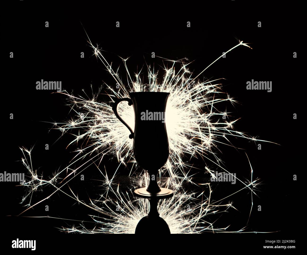 Coupe trophée silhouette sur fond d'étincelles brillantes. Monochrome. Banque D'Images