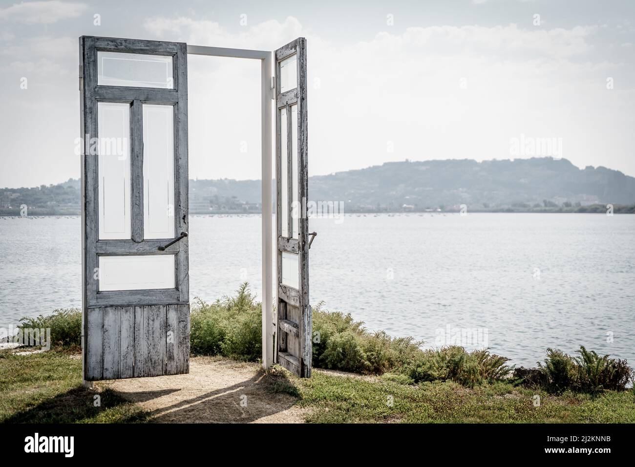 Porte ouverte symbolique en bois sur un lac, concept de porte ouverte à la nature et au changement climatique. Banque D'Images