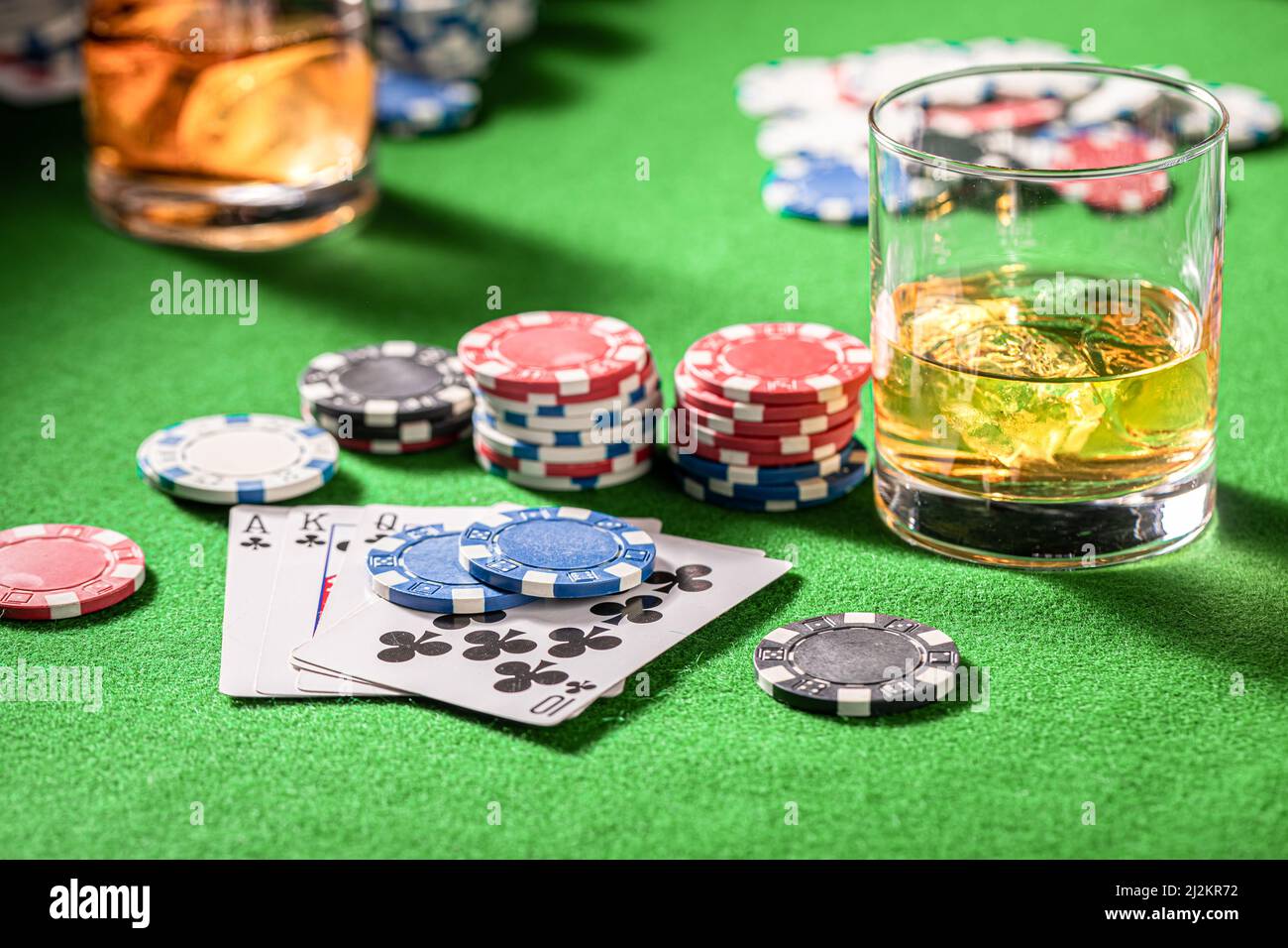 Table de jeu de poker avec cartes, jetons et chiksy. Table de poker avec cartes, jetons et un verre de whisky avec glace. Banque D'Images