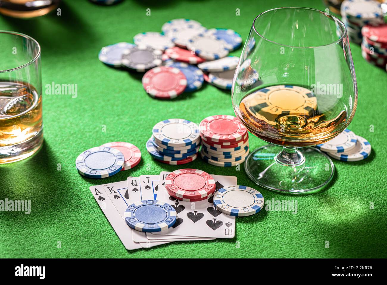 Gros plan de la table de poker avec des cartes, des jetons et des chiksy. Table de poker avec cartes, jetons et un verre de whisky avec glace. Banque D'Images