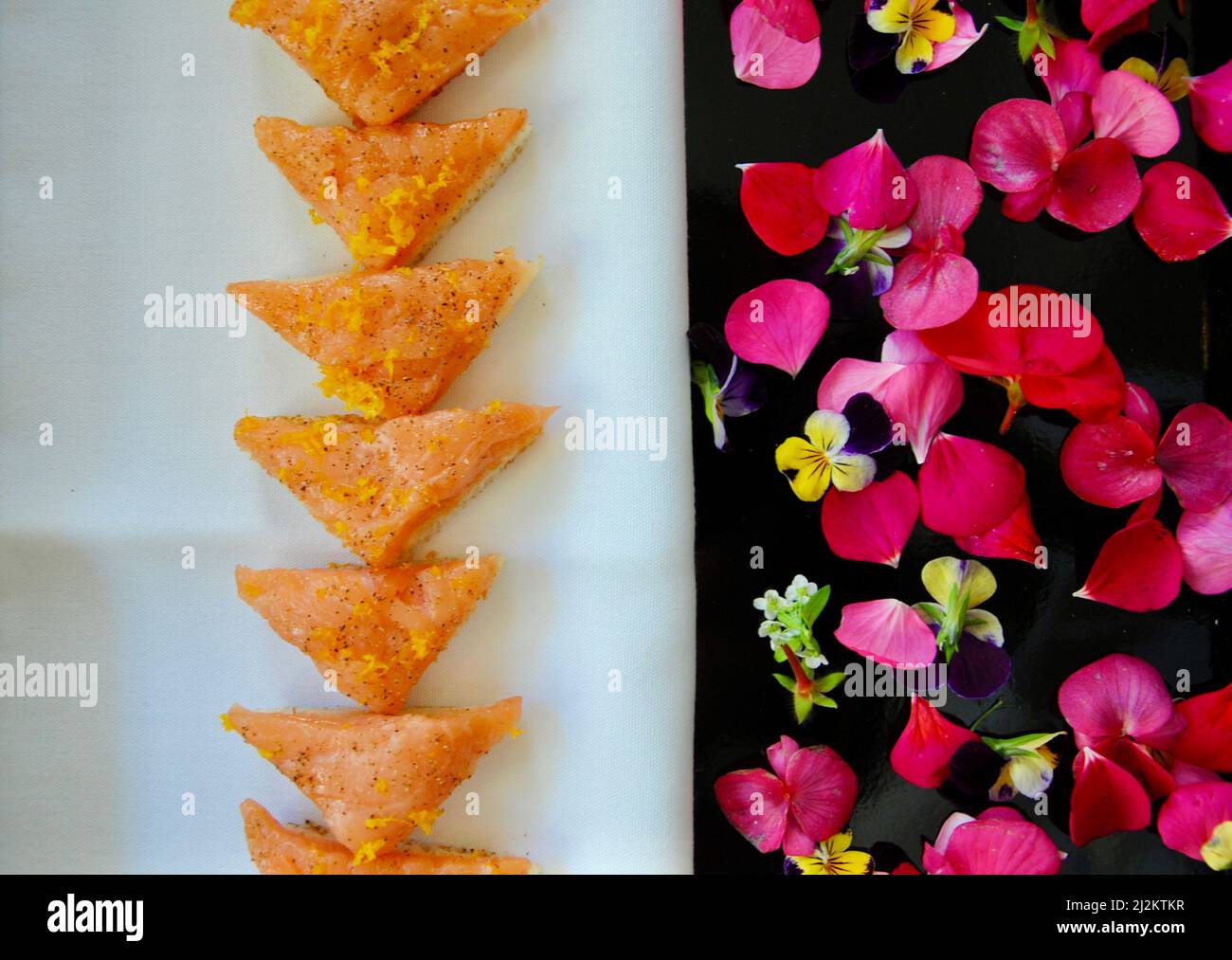 Canapés au saumon fumé sur plateau décoré de fleurs comestibles Banque D'Images