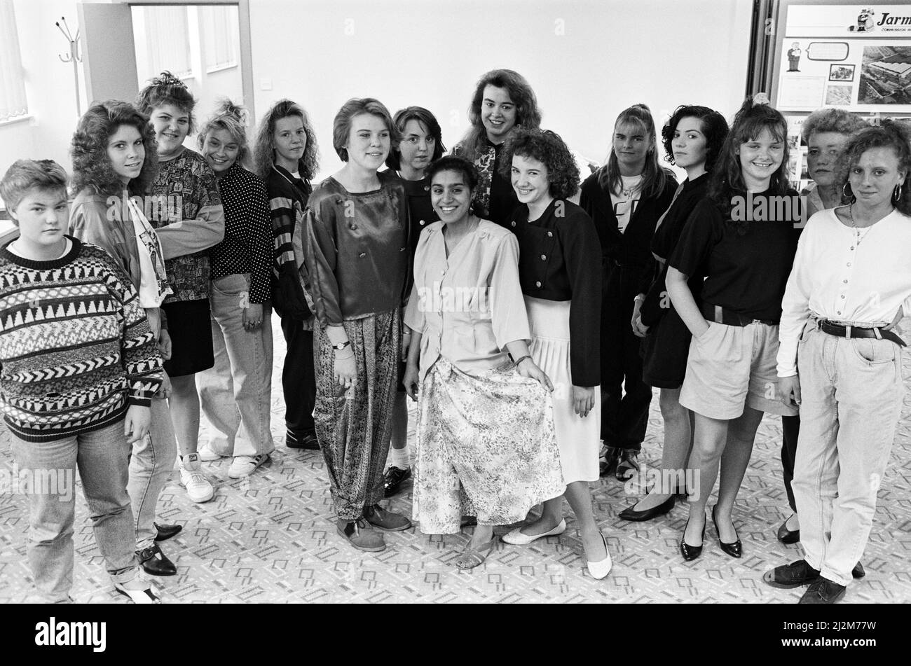 La mode sur une corde à chaussures... prouvant que vous n'avez pas besoin de loadsa-argent pour couper un trait sont ces entrepreneurs de l'industrie de l'habillement YTS stagiaires. Ils ont pris part à la passerelle pour un défilé de mode organisé par la Clothing Group Training Association à la maison textile de Huddersfield, rue St Andrew. Vingt-quatre créateurs en herbe ont été invités à compléter deux tenues avec un budget de seulement £15. Les élèves sont photographiés en portant leurs dessins (au centre) tandis que d'autres regardent. 15th mai 1990. Banque D'Images