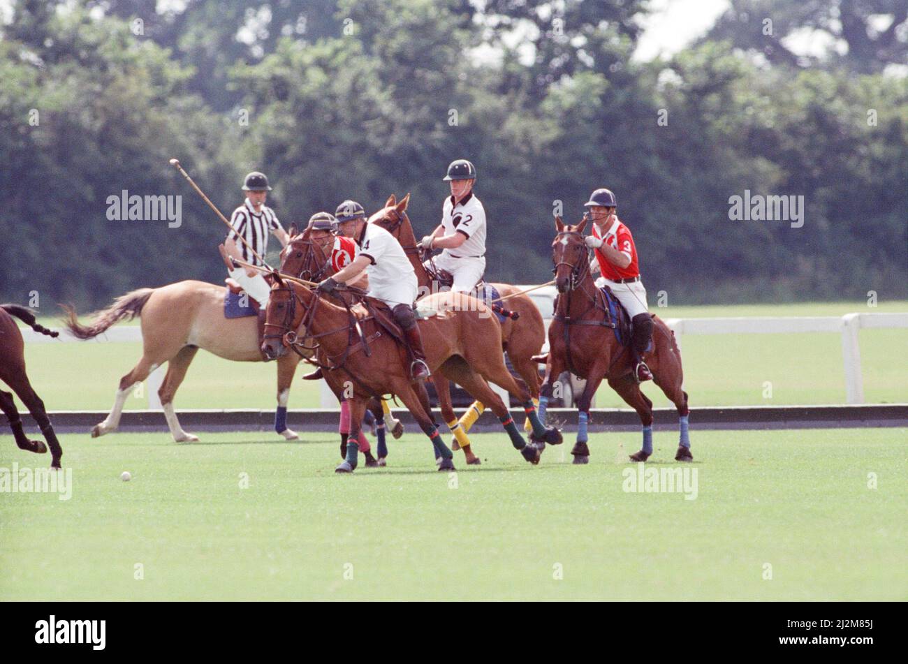 Le Prince Charles (maillot rouge portant le numéro 3) a été enfermé dans une bataille féroce contre le Major James Hewitt, ami de la princesse Diana aujourd'hui (maillot blanc portant le numéro 2) , sur le terrain de polo. À une étape, comme le major Hewitt a défié le prince, le commentateur a exclamé 'Oh, je dis ! Cette sortie était un peu difficile » malgré la détermination de Charles, l'équipe du héros du Golfe a remporté 4-1 victoires à Windsor. Les prix du polo ont été remis par une autre royale, la princesse Beatrice, fille de deux ans de la duchesse de York et du prince Andrew. Photo prise le 16th juillet 1991 Banque D'Images