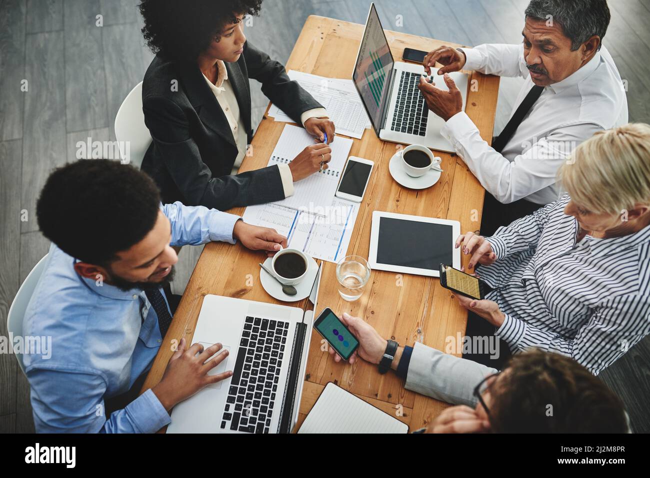 Travailler à partir de plusieurs appareils. Photo d'un groupe d'hommes d'affaires ayant une réunion dans un bureau. Banque D'Images