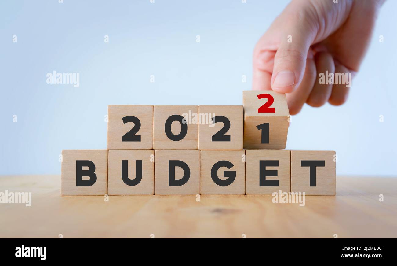 Concept de plan d'affaires de la nouvelle année en 2022. La main masculine retourne le cube en bois et change l'inscription 'BUDGET 20201' en 'BUDGET 2022' avec du backgroun blanc Banque D'Images