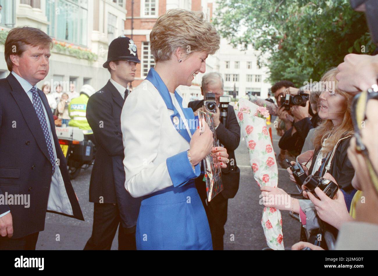 HRH la princesse de Galles, la princesse Diana, arrive à l'hôtel Savoy de Londres pour son anniversaire de 30th.les adeptes sont à l'extérieur pour donner ses fleurs et ses cadeaux. Le protège-corps Ken Wharf se tient derrière la princesse dans une veste bleue et une cravate bleue/blanche à motifs. Photo prise le 1st juillet 1991 Banque D'Images