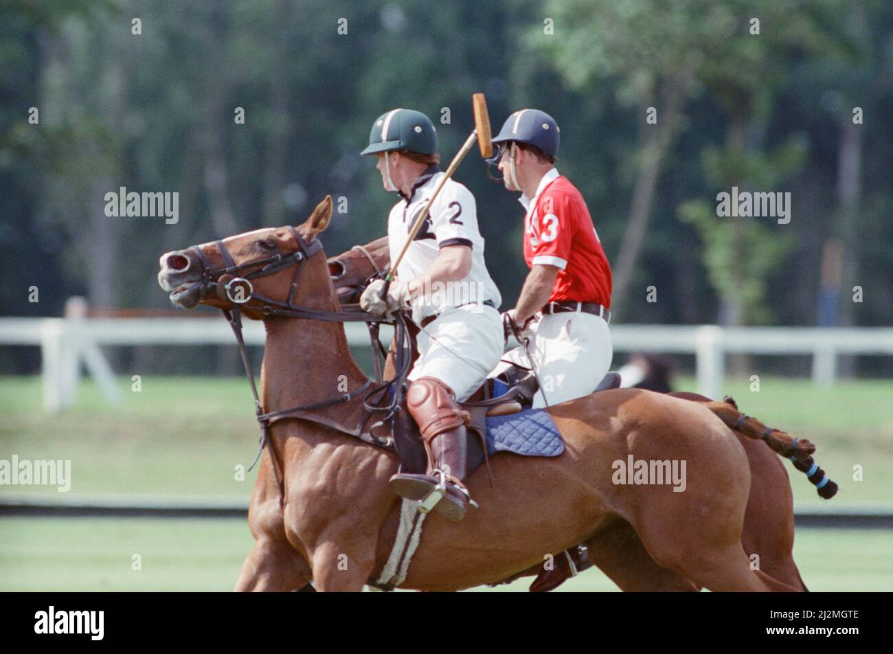 Le Prince Charles (maillot rouge portant le numéro 3) a été enfermé dans une bataille féroce contre le Major James Hewitt, ami de la princesse Diana aujourd'hui (maillot blanc portant le numéro 2) , sur le terrain de polo. À une étape, comme le major Hewitt a défié le prince, le commentateur a exclamé 'Oh, je dis ! Cette sortie était un peu difficile » malgré la détermination de Charles, l'équipe du héros du Golfe a remporté 4-1 victoires à Windsor. Les prix du polo ont été remis par une autre royale, la princesse Beatrice, fille de deux ans de la duchesse de York et du prince Andrew. Photo prise le 16th juillet 1991 Banque D'Images