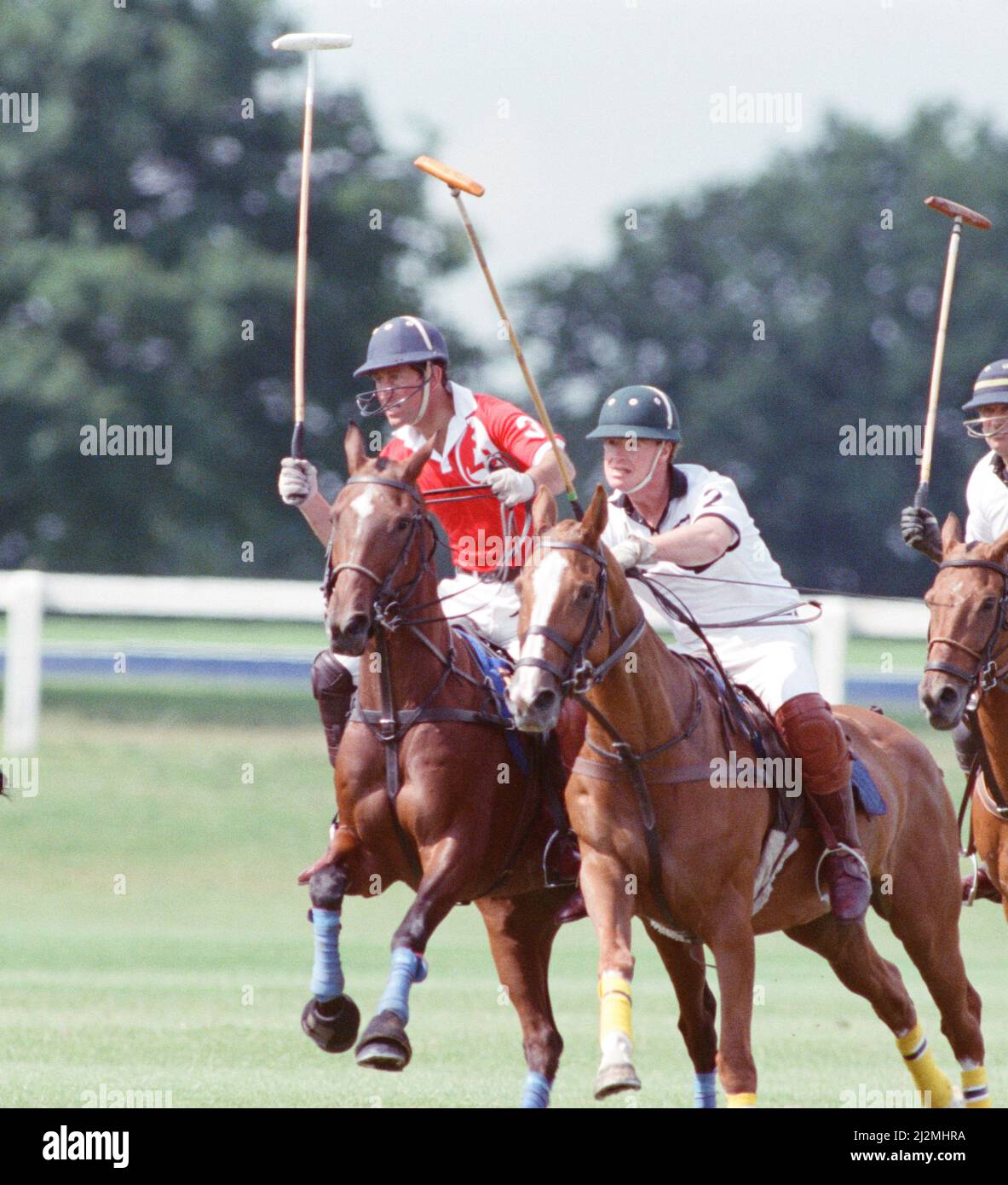 Le Prince Charles (maillot rouge portant le numéro 3) a été enfermé dans une bataille féroce contre le Major James Hewitt, ami de la princesse Diana aujourd'hui (maillot blanc portant le numéro 2) , sur le terrain de polo. À une étape, comme le major Hewitt a défié le prince, le commentateur a exclamé 'Oh, je dis ! Cette sortie était un peu difficile » malgré la détermination de Charles, l'équipe du héros du Golfe a remporté 4-1 victoires à Windsor. Les prix du polo ont été remis par une autre royale, la princesse Beatrice, fille de deux ans de la duchesse de York et du prince Andrew. Photo prise le 16th juillet 1991 Banque D'Images