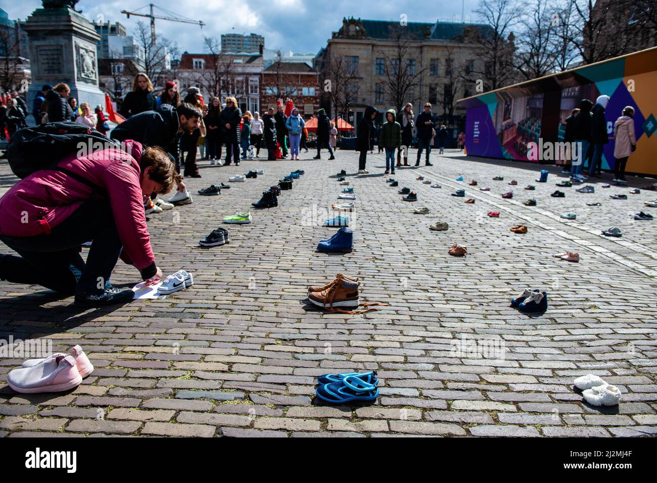 La Haye, pays-Bas. 02nd avril 2022. Un manifestant a vu placer des chaussures pour enfants sur le sol pendant la démonstration. Une installation artistique ukrainienne a été placée devant la Chambre des représentants des pays-Bas, pour attirer l'attention des autorités néerlandaises et de la population sur les meurtres de civils et en particulier d'enfants pendant la guerre en Ukraine. Crédit : SOPA Images Limited/Alamy Live News Banque D'Images